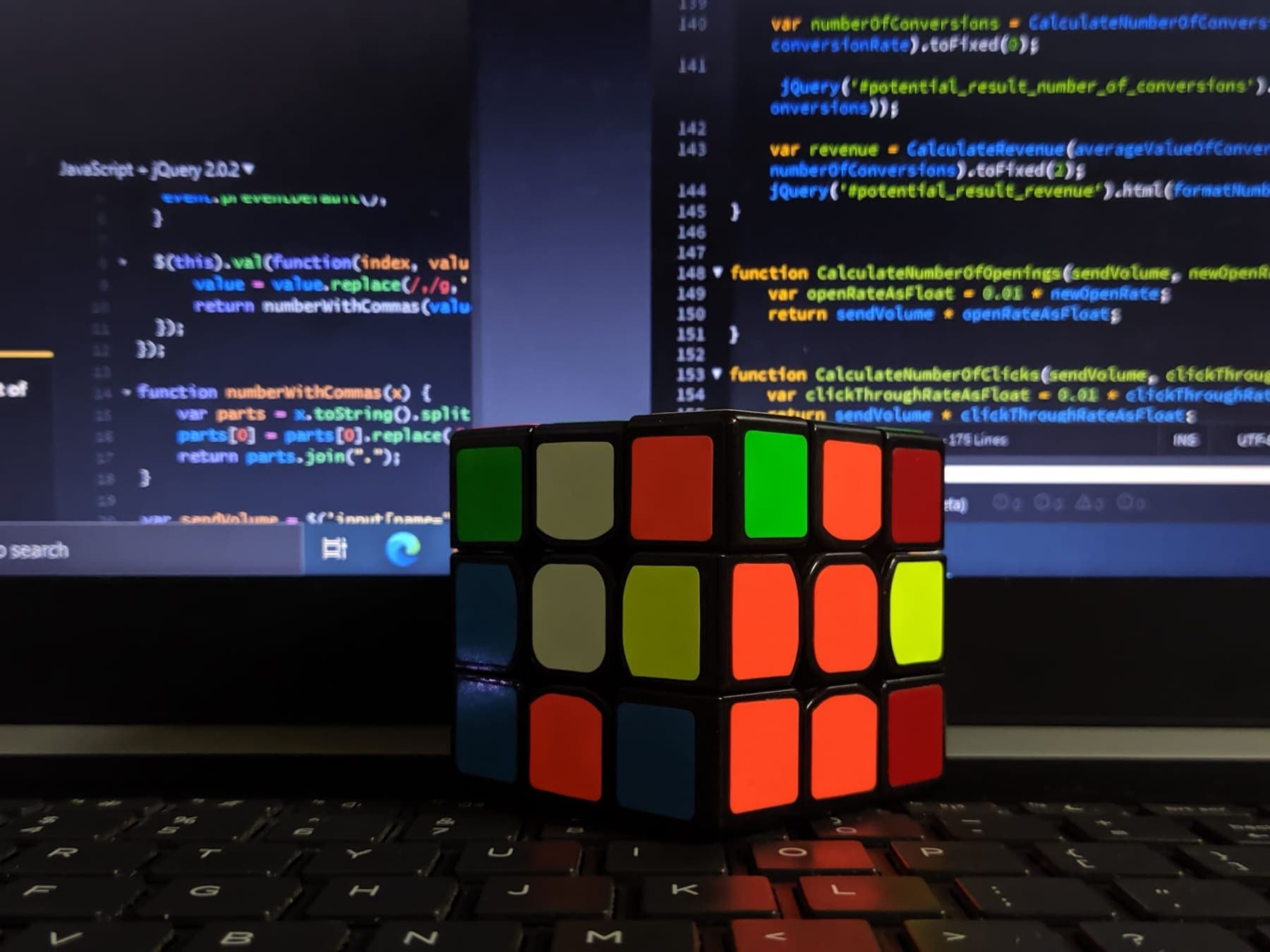 Rubik's cube in front of a screen of code